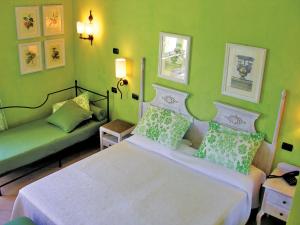 een groene slaapkamer met een bed en een bank bij iGV Club Vacanze Le Castella in Le Castella