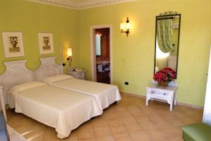 una camera con un grande letto e uno specchio di iGV Club Vacanze Le Castella a Le Castella