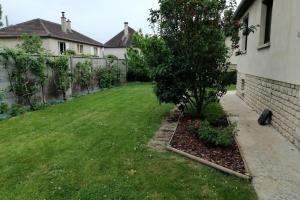 een tuin met een boom en een hek bij COSY HOUSE quite house in quite place in Bayeux