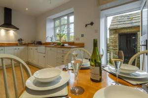 a kitchen with a table with a bottle of wine at Knights Rest in Redmire