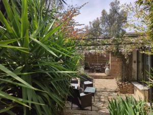 a garden with a pergola and a table and chairs at Cœur d'Hérault in Péret