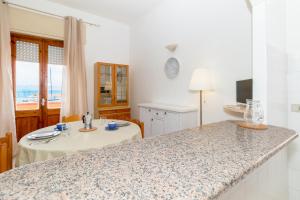 a kitchen with a counter top and a table at Casa Spiaggia Molo 2 in Isola Rossa