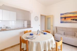 a living room with a table and a couch at Casa Spiaggia Molo 2 in Isola Rossa