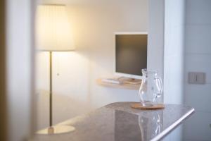 a glass vase sitting on a table next to a lamp at Casa Spiaggia Molo 2 in Isola Rossa +18 photos