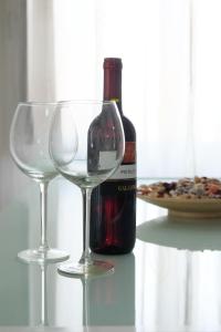 una botella de vino y dos copas de vino en una mesa en Casa Vacanze Marconi, en Caltagirone