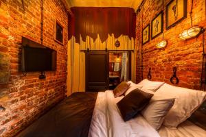 sypialnia z łóżkiem w ceglanej ścianie w obiekcie Mysterio Hotel w Petersburgu