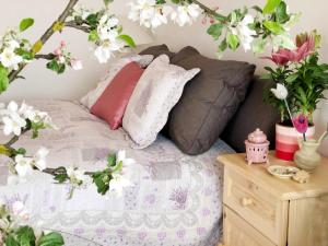1 cama con flores y almohadas rosas y blancas en Balaton Apartman Paloznak, en Paloznak