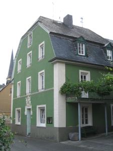 een groen en wit gebouw met een zwart dak bij Ferienhaus Schneiders in Kröv