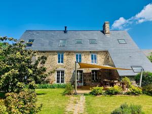 une grande maison en briques avec une tente dans la cour dans l'établissement Villa de la Plage avec sauna, à Dragey-Ronthon