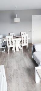 ein weißes Zimmer mit einem Esstisch und Stühlen in der Unterkunft Piso 100 metros del Centro del Pueblo 6 kilómetros de la PLAYA La BARROSa in Chiclana de la Frontera + 15 Fotos