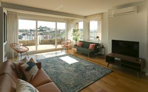 a living room with a couch and a flat screen tv at Villa D'Ouro in Porto
