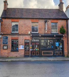 een bakstenen gebouw op de hoek van een straat bij George & Dragon Inn in Chichester