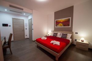 a bedroom with a red bed with two towels on it at Perla del sud in Sava