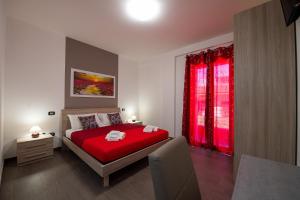 a bedroom with a red bed and a red window at Perla del sud in Sava +29 photos