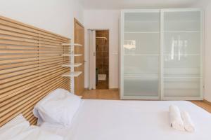 een slaapkamer met een wit bed en een glazen wand bij 4 bedroom apartment near the beach! in Setúbal