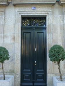 a black door on a building with two bushes at Hotel Bracara Augusta in Braga
