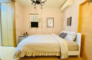 sypialnia z białym łóżkiem i żyrandolem w obiekcie Mori de house in Kobe 201 w mieście Kobe