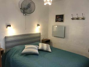 ein Schlafzimmer mit einem Bett mit zwei Kissen und einem Ventilator in der Unterkunft Apartamento Terrassa 1 in Tossa de Mar