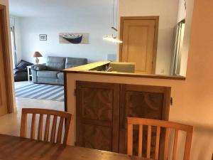 eine Küche mit einem Tisch und Stühlen sowie ein Wohnzimmer in der Unterkunft Apartamento Terrassa 1 in Tossa de Mar