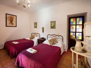 a room with two beds and a stained glass window at Cortijo La Gineta in Alcalá la Real +27 photos