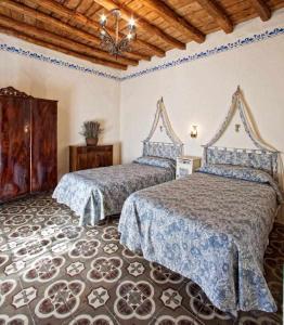 een slaapkamer met 2 bedden en een houten plafond bij Cortijo Rural La Gineta Alcalá la Real in Alcalá la Real