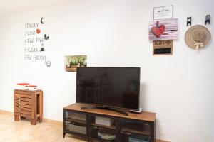 a flat screen tv sitting on top of a wooden entertainment center at Casita Corazón in Caleta de Sebo