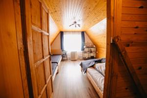 ein Schlafzimmer im Dachgeschoss mit einem Bett und einem Fenster in der Unterkunft Kedvesem Noszvaj in Noszvaj