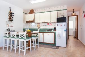 a kitchen with white cabinets and a white refrigerator at Casita Corazón in Caleta de Sebo