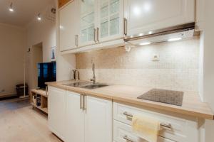 uma cozinha com armários brancos e um lavatório em COMMODUS apartment IX em Banská Štiavnica