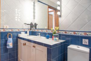 a bathroom with a sink and a mirror and a toilet at Casita Corazón in Caleta de Sebo +11 photos