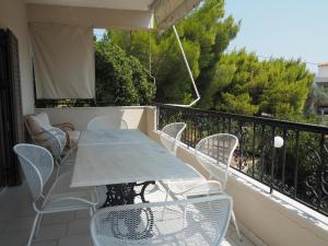 a patio with a table and chairs on a balcony at Villa Kavos - Isthmia Corinth in Isthmia