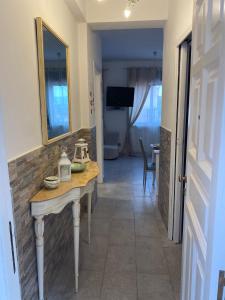 a hallway with a table and a mirror in a room at Halley House in Mondello +55 photos