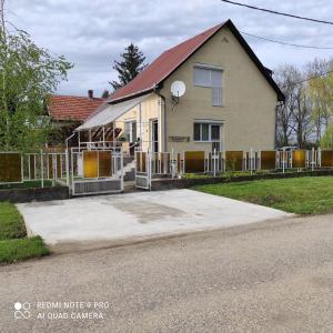 ein Haus mit einem Zaun davor in der Unterkunft Apartman Garami Porta in Mezőkövesd