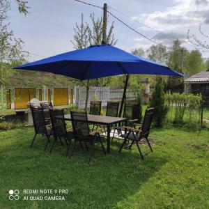 einen Tisch und Stühle unter einem blauen Schirm in der Unterkunft Apartman Garami Porta in Mezőkövesd