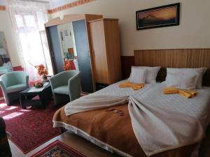 a bedroom with a large bed with two towels on it at Róza vendégszoba in Keszthely