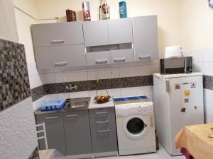 a small kitchen with a washing machine and a washer at Róza vendégszoba in Keszthely +4 photos