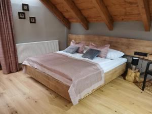 a bedroom with a large bed with pink pillows at Koliba na vršku in Bytča