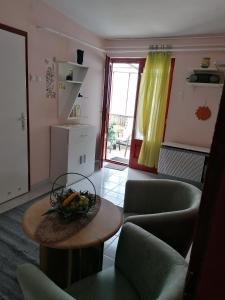 uma sala de estar com mesa e cadeiras em Róza vendégszoba em Keszthely