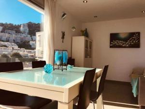 una sala da pranzo con tavolo e sedie bianchi di Apartamento Cala Salionç Playa frente a la playa y encima del Mar a Tossa de Mar
