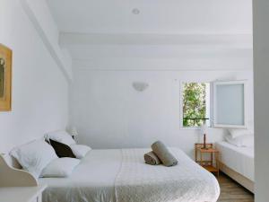 a white bedroom with a bed and a window at auberge de tesa in Occhiatana