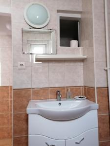 a bathroom with a white sink and a mirror at Róza vendégszoba in Keszthely
