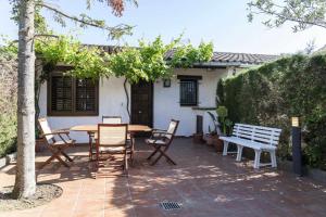 um pátio com uma mesa e cadeiras e um banco em Casas Blanca 34 piscina Playa privada wifi em Tossa de Mar