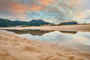 einen Strand mit Spiegelung des Himmels im Wasser in der Unterkunft Hotel Juan de la Cosa in Santoña