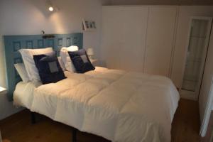 a bedroom with a large white bed with pillows at Cala LLevado Tossa de M. A/C Parking Piscina in Tossa de Mar +33 photos