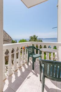 a balcony with two chairs and a table with the ocean in the background at Villa Kosa in Brela