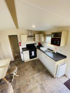 a kitchen with white cabinets and black counter tops at Lakeside Holiday rentals - Trieste in Great Billing