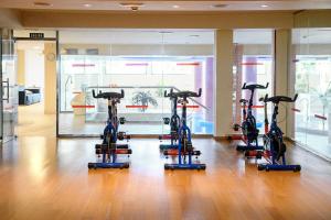 a gym with four treadmills in a room at R2 Buganvilla Hotel & Spa in Morro del Jable