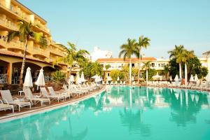 uma piscina com cadeiras e guarda-sóis num resort em R2 Buganvilla Hotel & Spa em Morro del Jable
