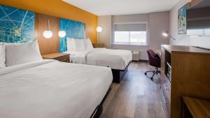 ein Hotelzimmer mit 2 Betten und einem Schreibtisch in der Unterkunft Best Western Plus Raleigh Crabtree Valley Hotel in Raleigh