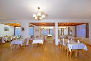 Hotel Alphubel في زيرمات: غرفة طعام مع طاولات وكراسي بيضاء